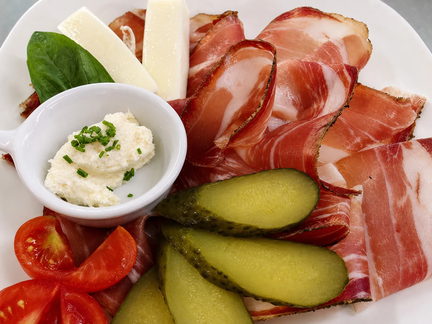 Tagliere di speck sudtirolese con formaggio e cetriolini