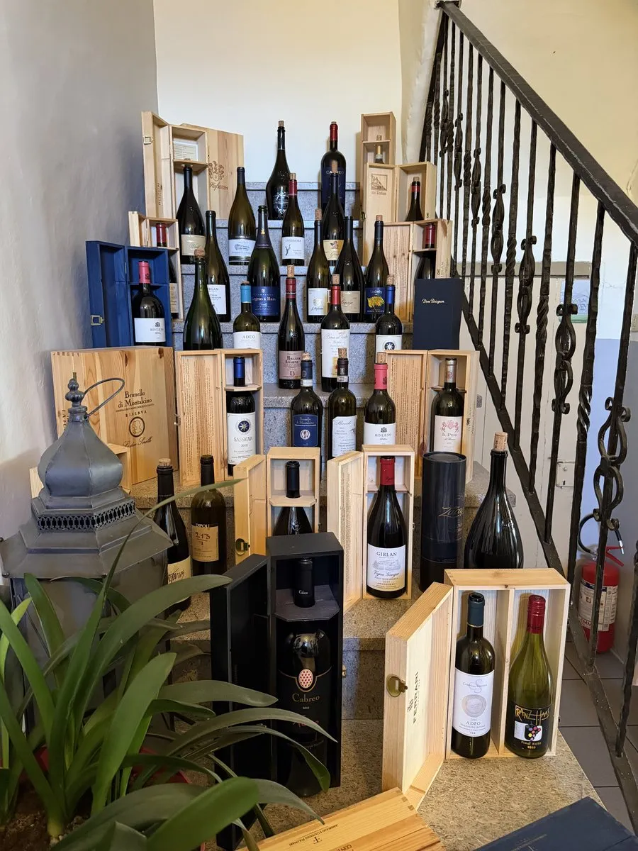 Weinsammlung in Holzkisten unter rustikaler Treppe